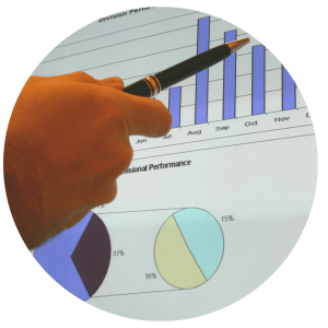 hand holding a pen pointing at bar graph displaying months