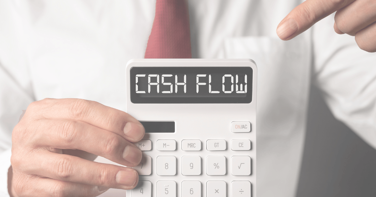 person in a suit and tie holding a calculator that says cash flow
